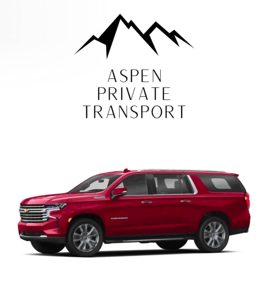 a red suv parked in front of a mountain.