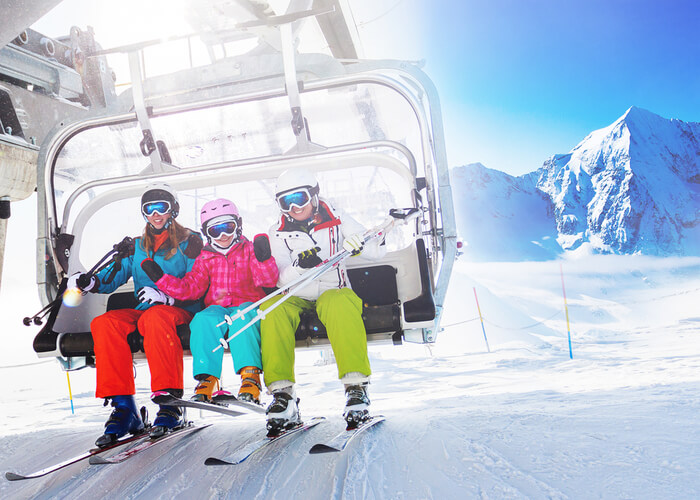 a group of people riding on top of a ski lift.